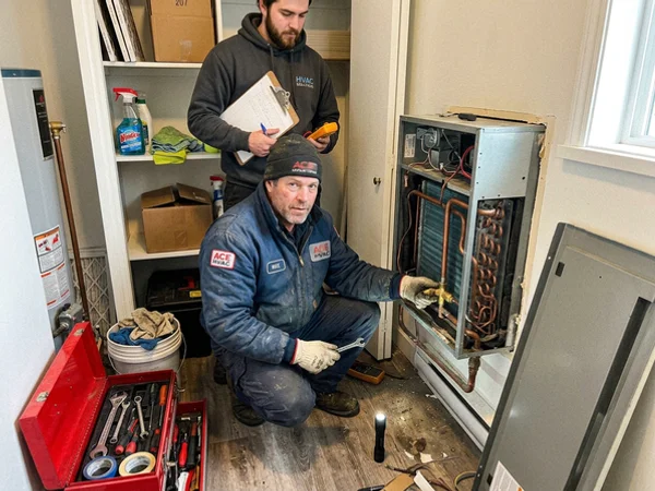 Condo fan coil unit being serviced in a utility closet